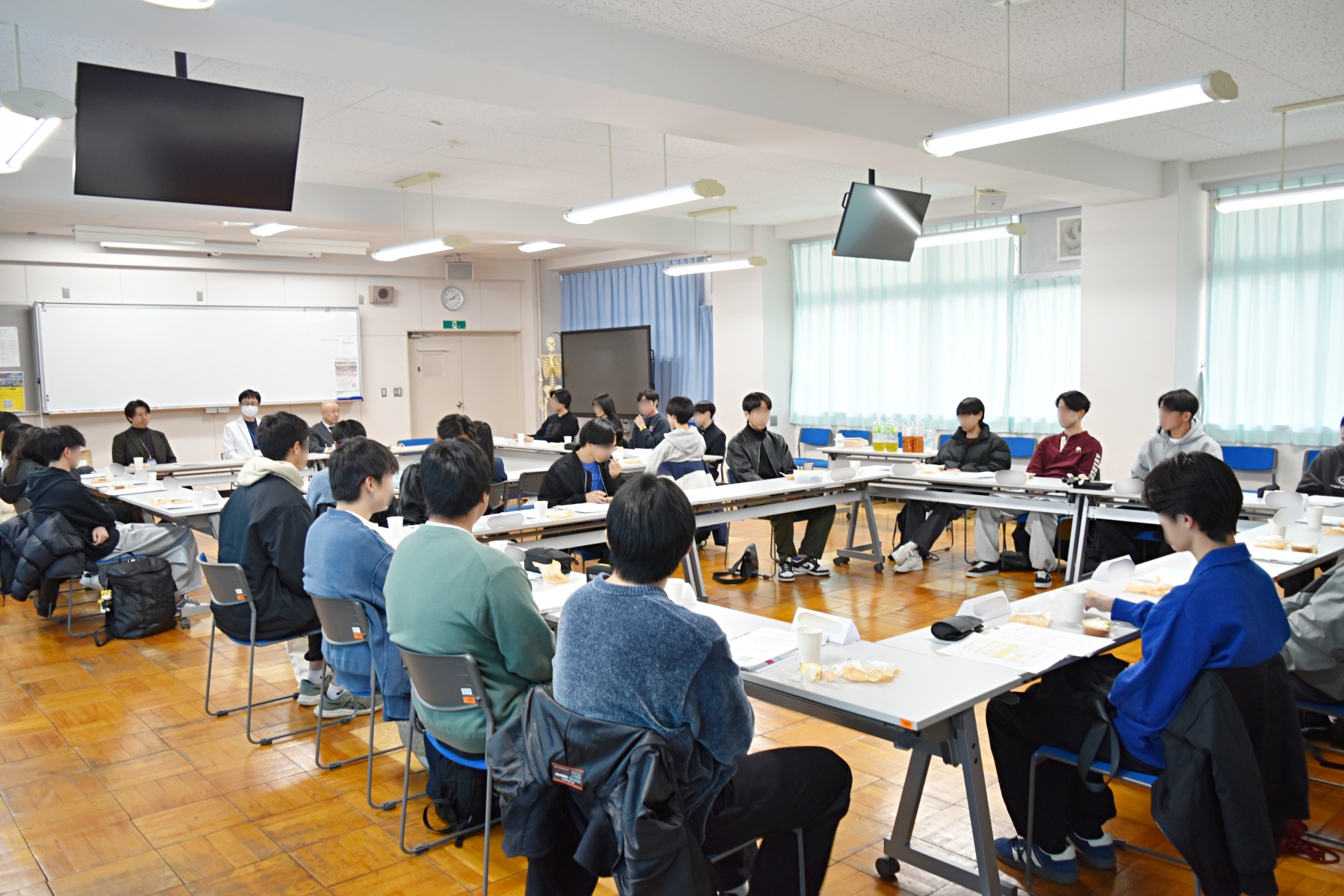 入学準備ミーティングで合格者が机を囲み、説明を受ける様子