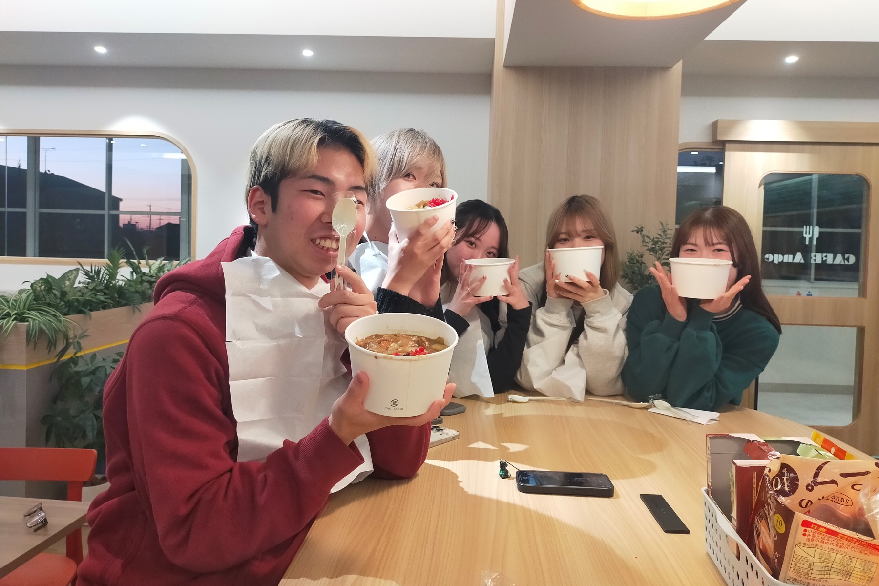 仲間同士でカレーを持って楽しそうに写真に写る学生たち