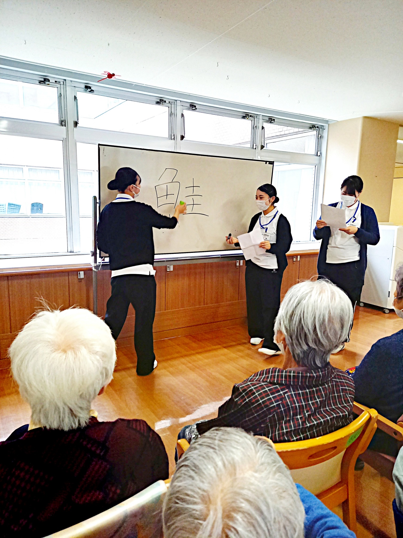 言葉ならびかえゲームに取り組む高齢者と学生の様子