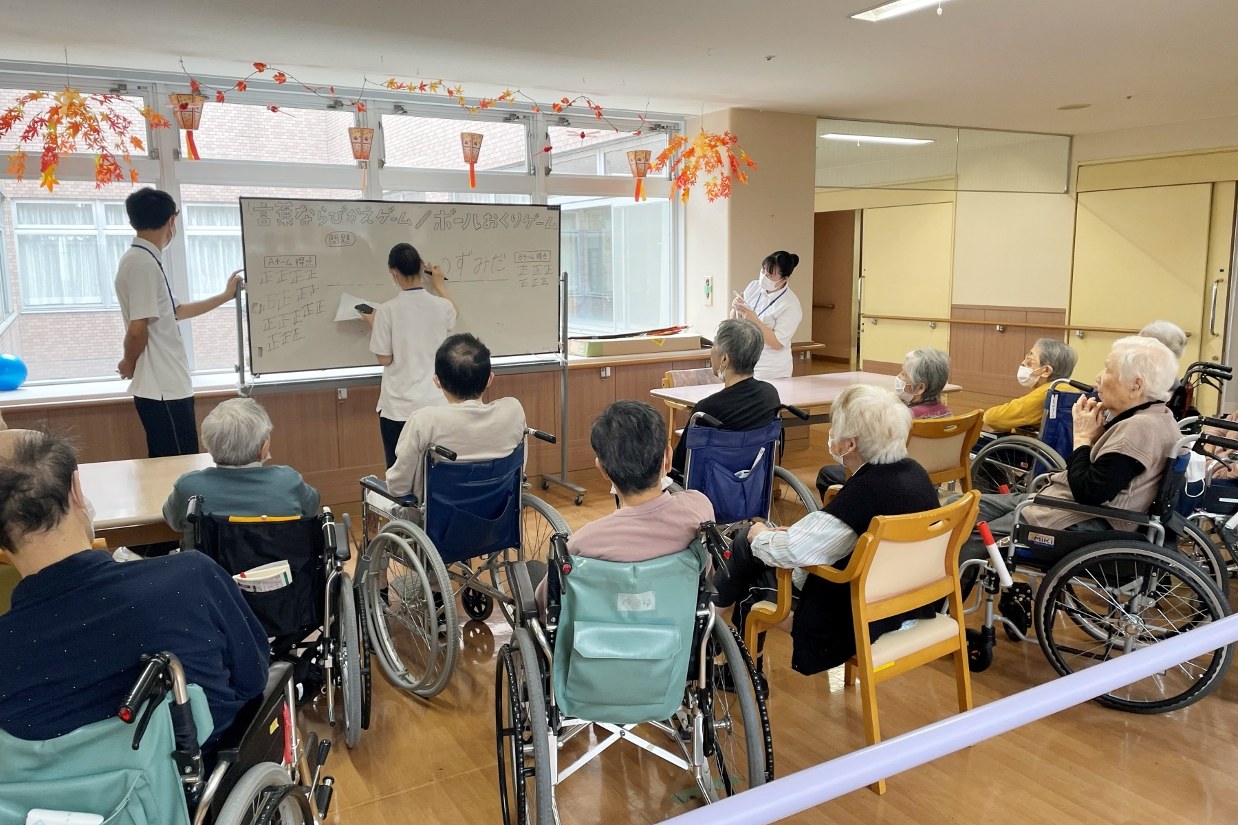 言葉ならびかえゲームとボールおくりゲームの得点を集計する学生の様子